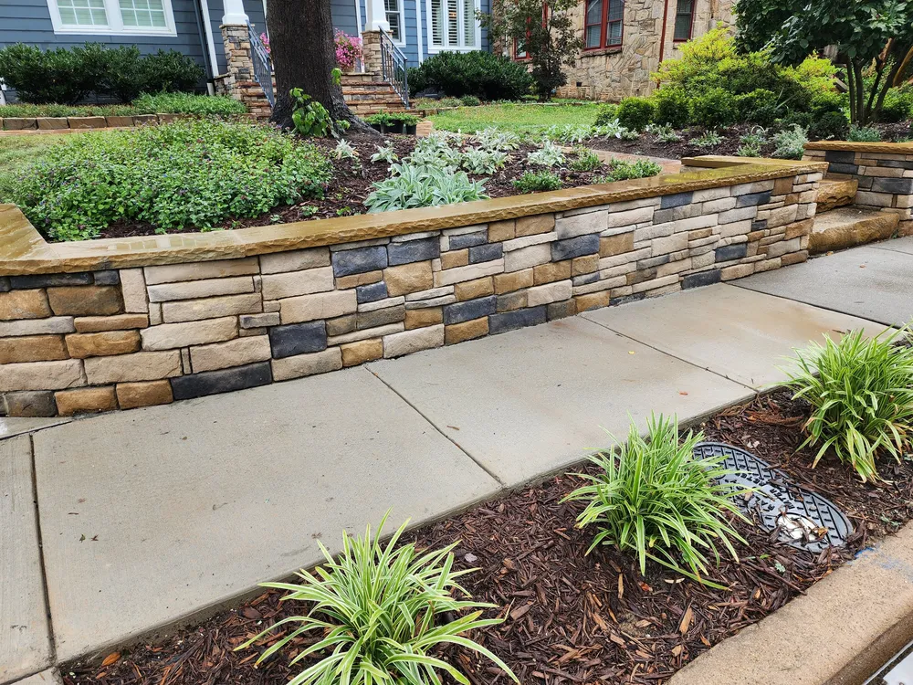 Close-up of the multi-tone stacked stone wall and sandstone steps beside new liriope plantings