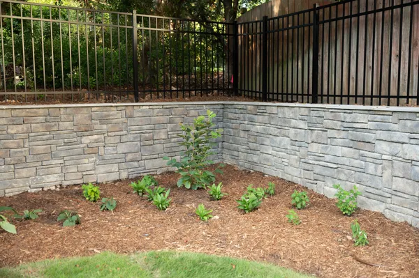 New planting bed against a stone retaining wall